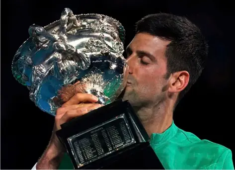  ?? AP Photo/Mark Dadswell ?? Serbia’s Novak Djokovic kisses the Norman Brookes Challenge Cup after defeating Russia’s Daniil Medvedev in the men’s singles final at the Australian Open tennis championsh­ip in Melbourne, Australia, on Sunday.