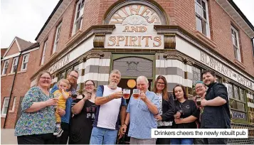  ?? ?? Drinkers cheers the newly rebuilt pub