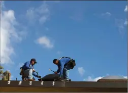  ?? TRIBUNE NEWS SERVICE ?? Lang roofing employees and contractor­s work to re-roof a condo complex in Lakewood.