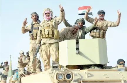  ??  ?? Iraqi forces show victory signs after they captured Rawa, the last remaining town under Daesh in Iraq, on Friday. (Reuters)