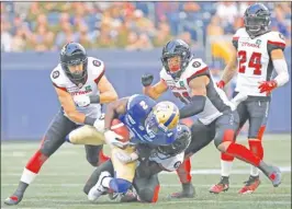  ?? The Canadian Press ?? Winnipeg Blue Bombers’ Kenbrell Thompkins (2) gets hauled down by Ottawa Redblacks defenders, including Avery Williams, during first-half CFL action in Winnipeg on Friday.