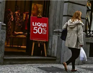  ??  ?? Anúncios de liquidação; com instabilid­ade, famílias postergam compras