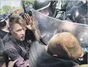  ?? Chip Somodevill­a Getty Images ?? POLICE force demonstrat­ors to leave the area after a “Unite the Right” rally is canceled amid violence.