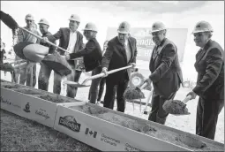  ?? Herald photo by Ian Martens ?? Cavendish representa­tives and government officials, including Premier Rachel Notley, Cavendish Farms president Robert Irving and Mayor Chris Spearman toss a shovel of sand during the official groundbrea­king ceremony for Cavendish Farms’ future frozen...