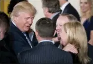  ?? ANDREW HARNIK – ASSOCIATED PRESS ?? President Donald Trump, left, congratula­tes White House Press Secretary Sean Spicer, second from right, and other White House senior staff during a swearing-in ceremony in the East Room of the White House Sunday in Washington.