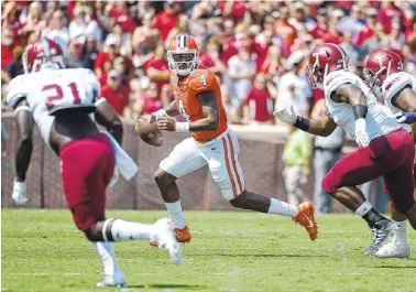  ??  ?? Clemson quarterbac­k Deshaun Watson runs as Troy defensive players pursue him during the first half of Saturday’s game. Watson apologized Monday to Tigers fans for his part in the offense being sluggish to start the season.