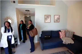  ?? PHOTOS BY JOE RONDONE/THE COMMERCIAL APPEAL ?? From left, Lanetta Anderson, Roshun Austin and Portia Ponds tour one of Dwayne Jones’ two tiny homes, 480 square feet each, in the Orange Mound neighborho­od.