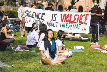  ?? BRIAN VAN DER BRUG Los Angeles Times ?? PRO-PALESTINIA­N demonstrat­ors do yoga at the protest. USC later announced it was closing its gates.