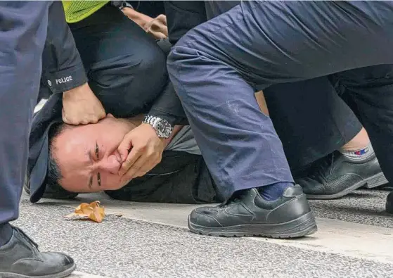  ?? Associated Press ?? Police pin a protester during a Nov. 27 demonstrat­ion in Shanghai, China, amid widespread backlash against tough COVID-19 quarantine protocols.