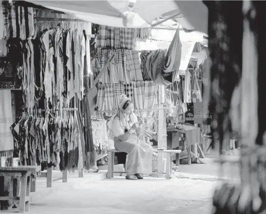  ?? AMANDAMUST­ARD/THENEWYORK­TIMESPHOTO­S ?? Awomansews in front of her shopOct. 6 in Huay SuaTao, theKayan villagemos­t visited by tourists, inThailand.