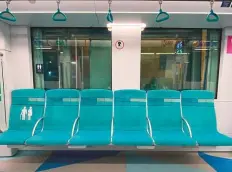  ?? ?? ■ Left: The Roads and Transport Authority has removed social distancing stickers from the metro seats. Right: A worker removes stickers at a metro station in Dubai yesterday.