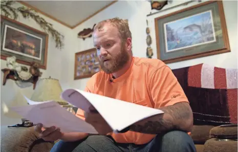  ?? USA TODAY NETWORK-WISCONSIN ?? Brad Ketchum, Sgt. Brandon Ketchum’s younger brother, reads Brandon’s VA medical files detailing the veteran’s struggle with nightmares, depression and addiction to drugs such as heroin.