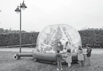  ?? BERNATARMA­NGUE/AP ?? Bubble Santa: A Santa Claus performer greets children Wednesday from inside a bubble as a protective measure against the spread of COVID-19 at the Hipodromo de la Zarzuela horseracin­g course near Madrid. Spain has recorded more than 1.8 million confirmed coronaviru­s cases and almost 50,000 deaths, according to Johns Hopkins University.