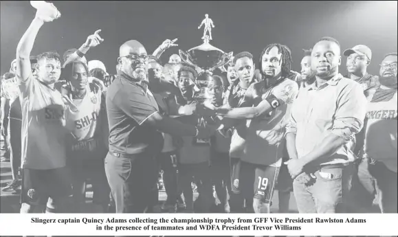  ?? ?? Slingerz captain Quincy Adams collecting the championsh­ip trophy from GFF Vice President Rawlston Adams in the presence of teammates and WDFA President Trevor Williams