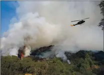  ?? JANE TYSKA — STAFF PHOTOGRAPH­ER ?? A helicopter refills water for an air drop as the Glass Fire burns about a mile out of downtown Calistoga on Wednesday.