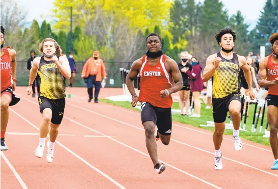  ?? APRIL GAMIZ/THE MORNING CALL ?? Easton’s Marcus Williams, center, won the 100-meter dash in 10.82 seconds in the Red Rovers’ dual-meet victory over Freedom on Thursday.