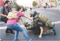  ??  ?? Riot police detain a demonstrat­or during a rally outside the US embassy against the American airstrikes on Syria in Santiago, Chile on Saturday.