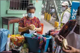  ?? ?? An indigenous woman counts corn tortillas Oct. 16 at La Palmita market in Guatemala City.