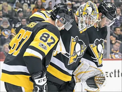  ??  ?? Matt Murray, center, had to be helped off the ice after being injured in the second period of the Penguins’ 5-4 victory Monday at PPG Paints Arena.