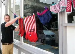  ??  ?? Dry humour: A local hangs out washing in front of a shop