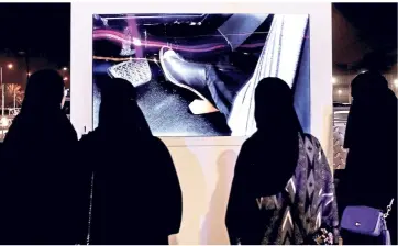  ??  ?? Saudi women watch a video about driving at a road safety event for female drivers; the lifting of the ban will enable women to travel without on men for transporta­tion.