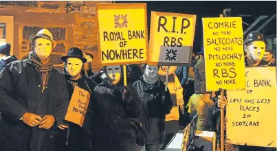  ?? Picture: Kim Cessford. ?? Comrie fancy dress entrants with their take on the RBS closure programme. However, their town’s branch may have been offered a lifeline to prove its profitabil­ity.