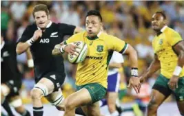  ??  ?? BRISBANE: In this Oct 18, 2014 file photo, Australia’s Christian Lealiifano, center, runs away from New Zealand’s Richie McCaw, left, during the Bledisloe cup rugby match against New Zealand in Brisbane, Australia. Leali’ifano played the last 30...