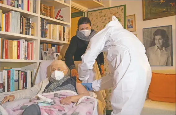  ?? (AP/Alessandra Tarantino) ?? Patrizia Cumbo, 96, flanked by her daughter Fiamma Spinelli, receives a dose of the Pfizer vaccine at her home in Rome.