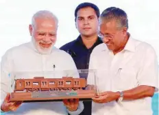  ?? — Reuters ?? Prime Minister Narendra Modi receives a model of Kochi Metro presented to him by Kerala Chief Minister Pinarayi Vijayan after he inaugurate­d Kochi Metro on Saturday.