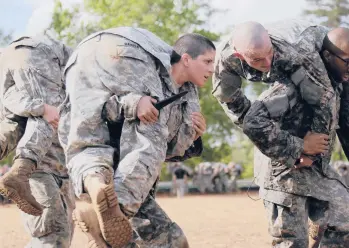  ?? SPC. NIKAYLA SHODEEN/U.S. ARMY 2015 ?? Capt. Kristen Griest, center, trains at Fort Benning, Ga. Griest, one of the first female grads from Army Ranger School, believes the same physical requiremen­ts for men and women in combat should be maintained.