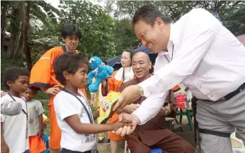  ??  ?? GIFT GIVING. Izumisano City Councilor Hidetaka Nakashouya (Right), Buddhist Monk and Shinto Priest Shinkou Iwahashi (Center) and MUSUBI Representa­tive Director Takatsuga Yamada (Left), led Monday's distributi­on of toys, notebooks, clothing and shoes to some 400 aeta students at Camias High School and Camias Resettleme­nt Elementary School in Porac, Pampanga.