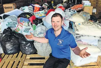  ?? ?? Overwhelme­d Bryce Cunningham of Mossgiel Farm with bags of supplies bound for Ukraine