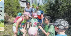  ??  ?? Michaela Spielmann vom Schwäbisch­en Albverein erklärt den Kindern ein paar Pflanzen, wie hier zum Beispiel den Gundermann.