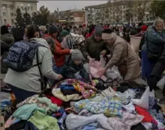  ?? Associated Press ?? Residents search among clothing donations at a distributi­on point in downtown Kherson in southern Ukraine on Friday.