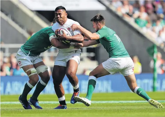  ?? PHOTO: GETTY IMAGES ?? On the charge . . . English midfield back Manu Tuilagi is tackled by Josh van der Flier (left) and Ross Byrne, of Ireland, in a match at Twickenham last month.