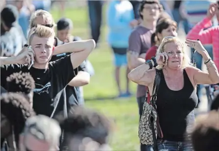  ?? AMY BETH BENNETT SOUTH FLORIDA SUN-SENTINEL VIA THE ASSOCIATED PRESS ?? Waiting for word from students, anxious family members gather just south of the Florida school where a shooting rampage took place Wednesday.