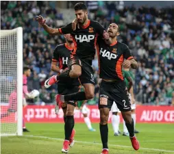  ?? (Maor Elkaslasi) ?? BNEI YEHUDA forward Yoanatan Cohen (center) celebrates after scoring his team’s second goal in last night’s 2-0 victory at Maccabi Haifa.