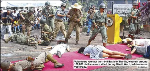  ?? EDD GUMBAN ?? Volunteers reenact the 1945 Battle of Manila, wherein around 100,000 civilians were killed during World War II, in Intramuros yesterday.