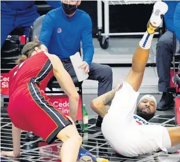  ?? MARK J. TERRILL/AP ?? Clippers forward Marcus Morris Sr., right, falls after scoring and drawing a foul from Heat forward Kelly Olynyk during the first half Monday in Los Angeles.