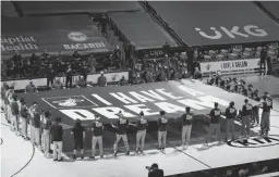 ?? MARTA LAVANDIER/AP ?? Heat and Pistons players hold an “I Have a Dream” banner in honor of Martin Luther King Jr. Day before Monday’s game in Miami.