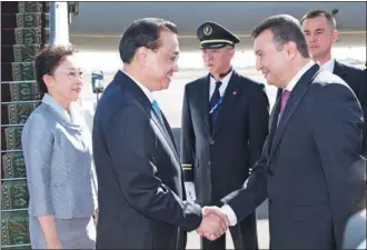  ?? HUANG JINGWEN / XINHUA ?? Premier Li Keqiang and wife, Cheng Hong, are greeted by Tajik Prime Minister Kokhir Rasulzoda on Thursday in Dushanbe for an official visit to Tajikistan. Li will also attend the 17th meeting of the Shanghai Cooperatio­n Organizati­on Heads of Government Council.