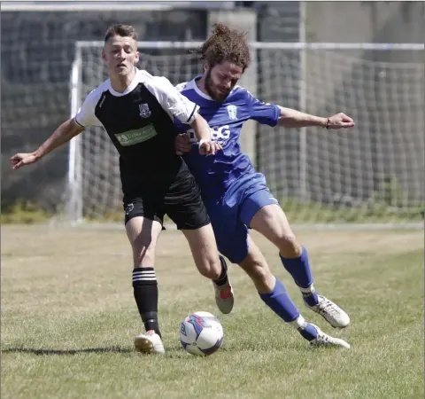  ??  ?? Newtown’s Ross Davis and Roundwood’s Robin Byrne collide during the Jim McLaughlin Trophy final in Shamrock Park, Rathnew.