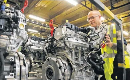  ?? Ap Photo/frank augstein ?? A Ford employee checks a fully assembled two-litre diesel engine, at the Ford Dagenham diesel engine plant in London, Friday, July 21.