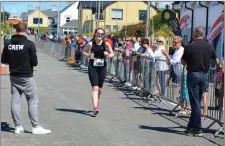  ?? Photo by Fergus Dennehy. ?? Emma O’Connor crosses the finish line to cheers at Fenit on Saturday morning.