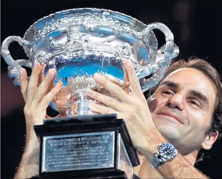  ?? Picture: PA ?? NICE TO SEE YOU AGAIN: Roger Federer gets his hands on the Australian Open trophy for the fifth time.