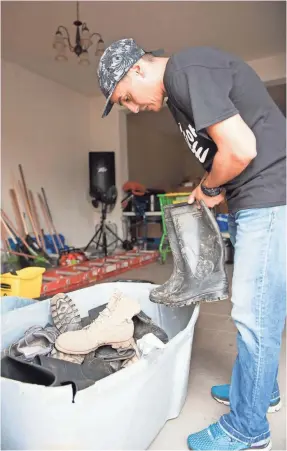  ??  ?? Pastor Humberto “Bert” Pizarro looks for his rubber boots before heading out to do hurricane relief work in Arecibo. PHOTOS BY JASPER COLT/USA TODAY