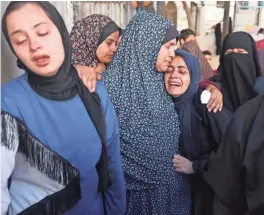  ?? AFP VIA GETTY IMAGES ?? A widow is supported by a relative Sunday during the funeral of Hamza Dahdouh, a journalist with the Al Jazeera television network, who was killed in a reported Israeli airstrike in Rafah in the Gaza Strip.