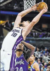  ?? Kevin Kolczynski The Associated Press ?? Kings forward Domantas Sabonis eyes the basket over Magic center Wendell Carter in Sacramento’s win Saturday.