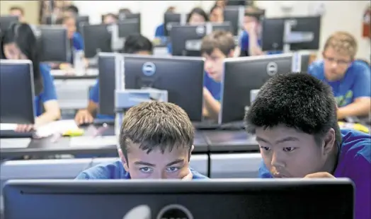  ?? Alex Driehaus/Post-Gazette ?? Duncan Caltagaron­e of Springdale, left, and Allen Gao of Point Breeze participat­e in a cyber camp competitio­n at the University of Pittsburgh's Cathedral of Learning.