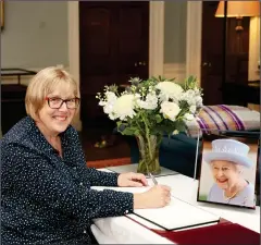  ?? ?? Marion Saunderson, signing the Book of Condolence­s for visitors at Castle Coole. Photo: John Mcvitty.